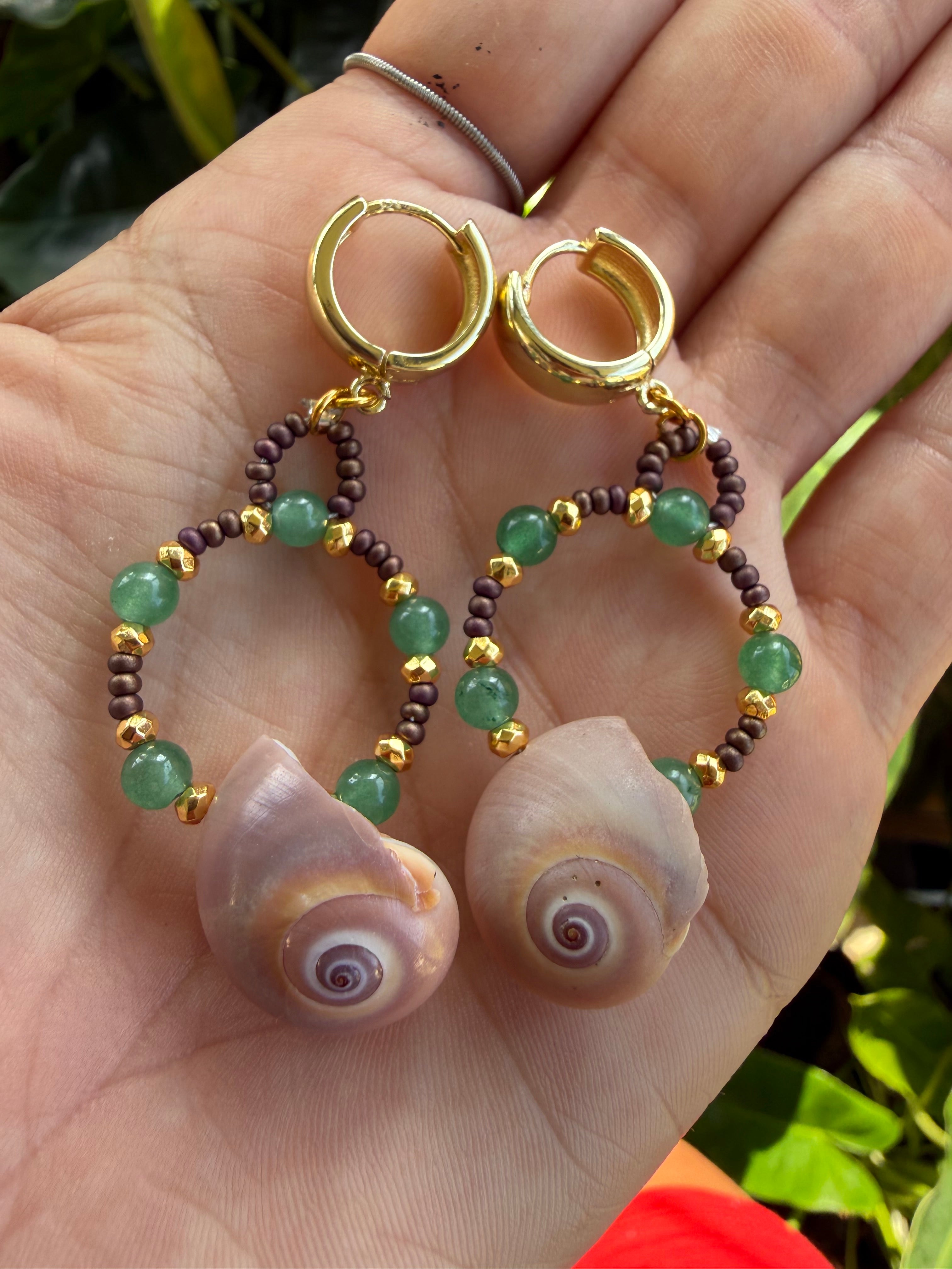 Shark eye earrings with gold, brown and green beads wi th gold cuff hooks.