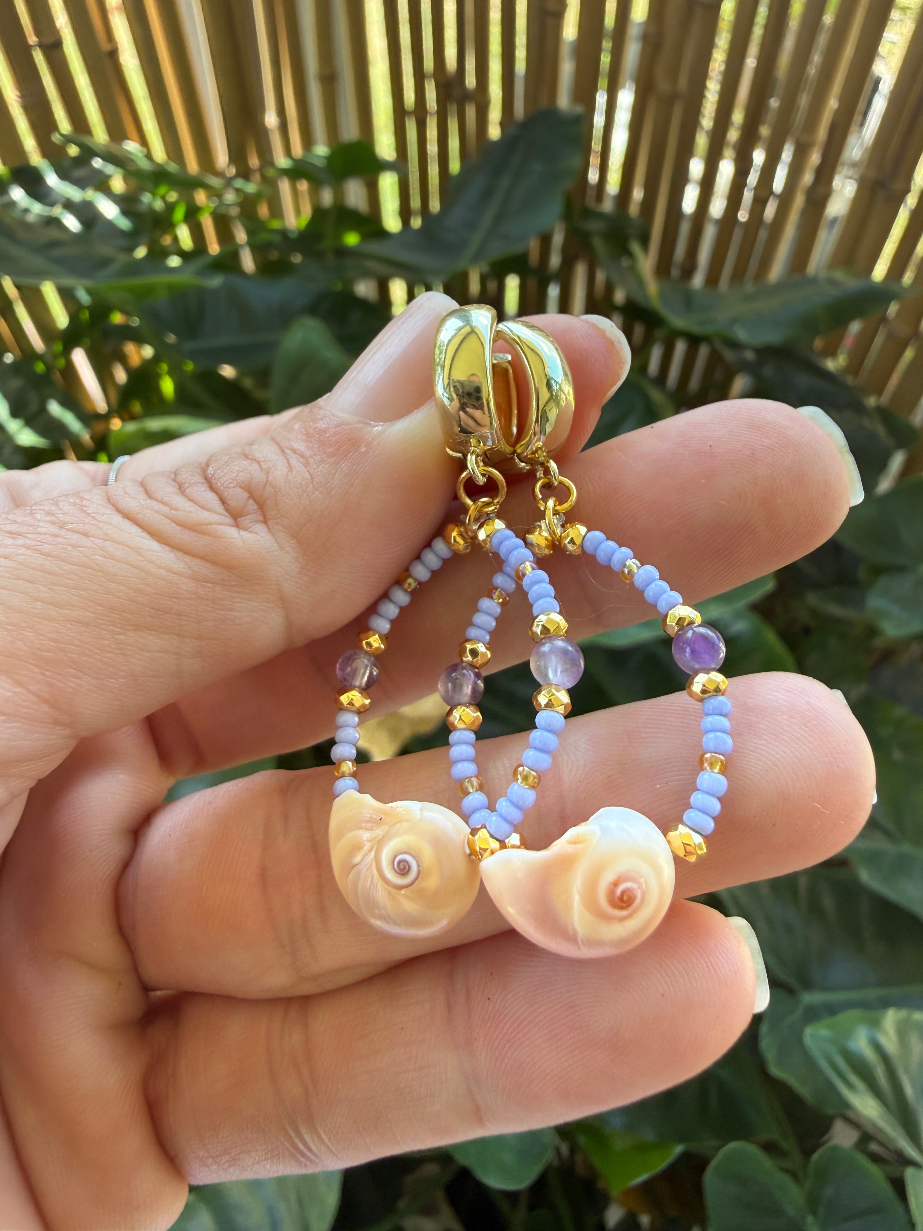 Mini shark eye shell earrings with amethyst, purple and gold beads. Gold cuff closure.