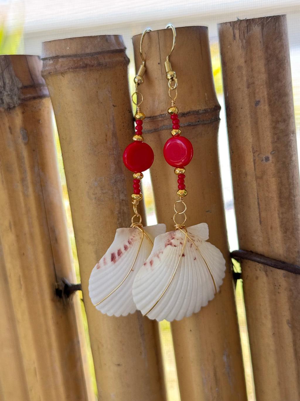 White scallop earrings with gold wire wrap, red and gold beads.